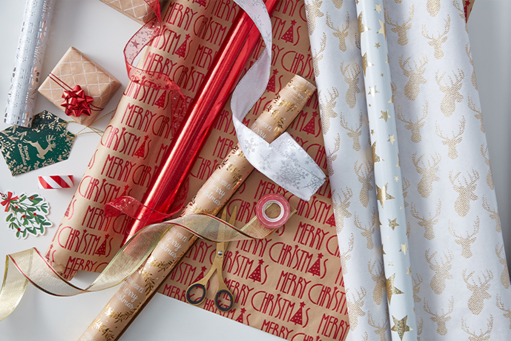 Papier na balenie vianočných darčekov, stuhy a baliace doplnky.