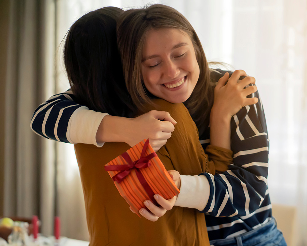 Dievča dáva darček svojej sestre a zároveň kamarátke.