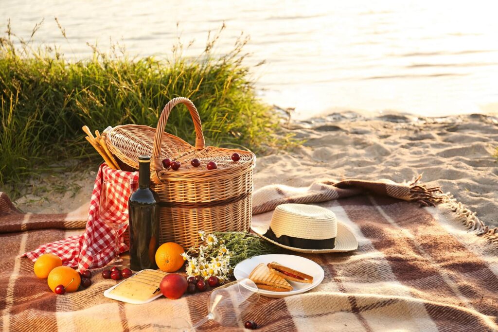 Piknikový kôš na romantickú večeru na pláži pri rieke.
