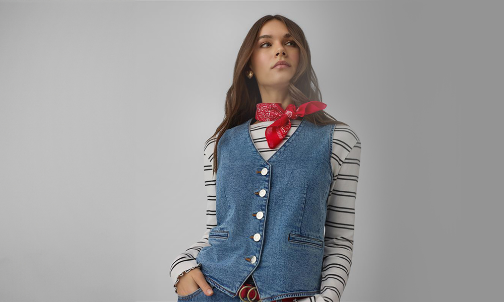 Žena má na sebe modrú džínovú vestu a červenú bandanu na krku.